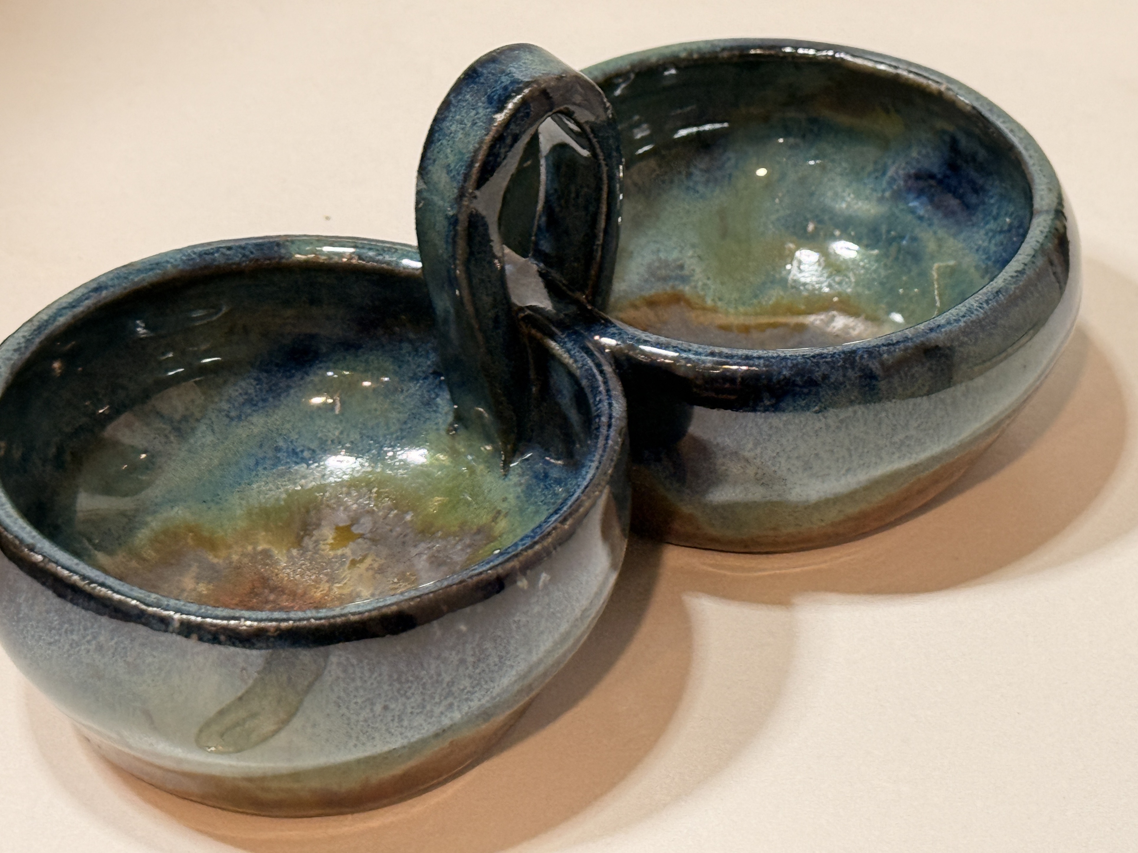 The finished bowls joined by a shared handle.