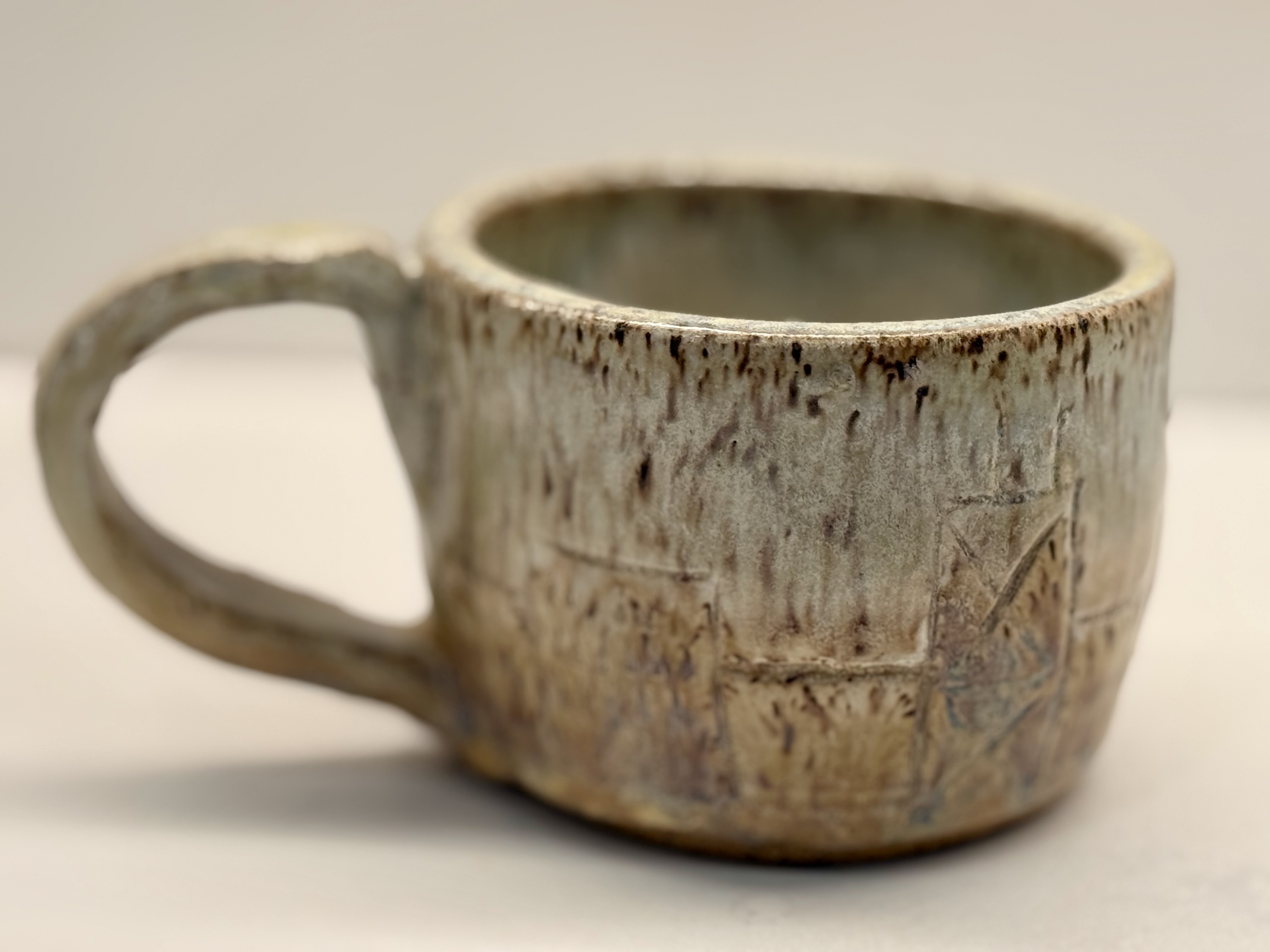 A pale glazed mug with a broad handle.